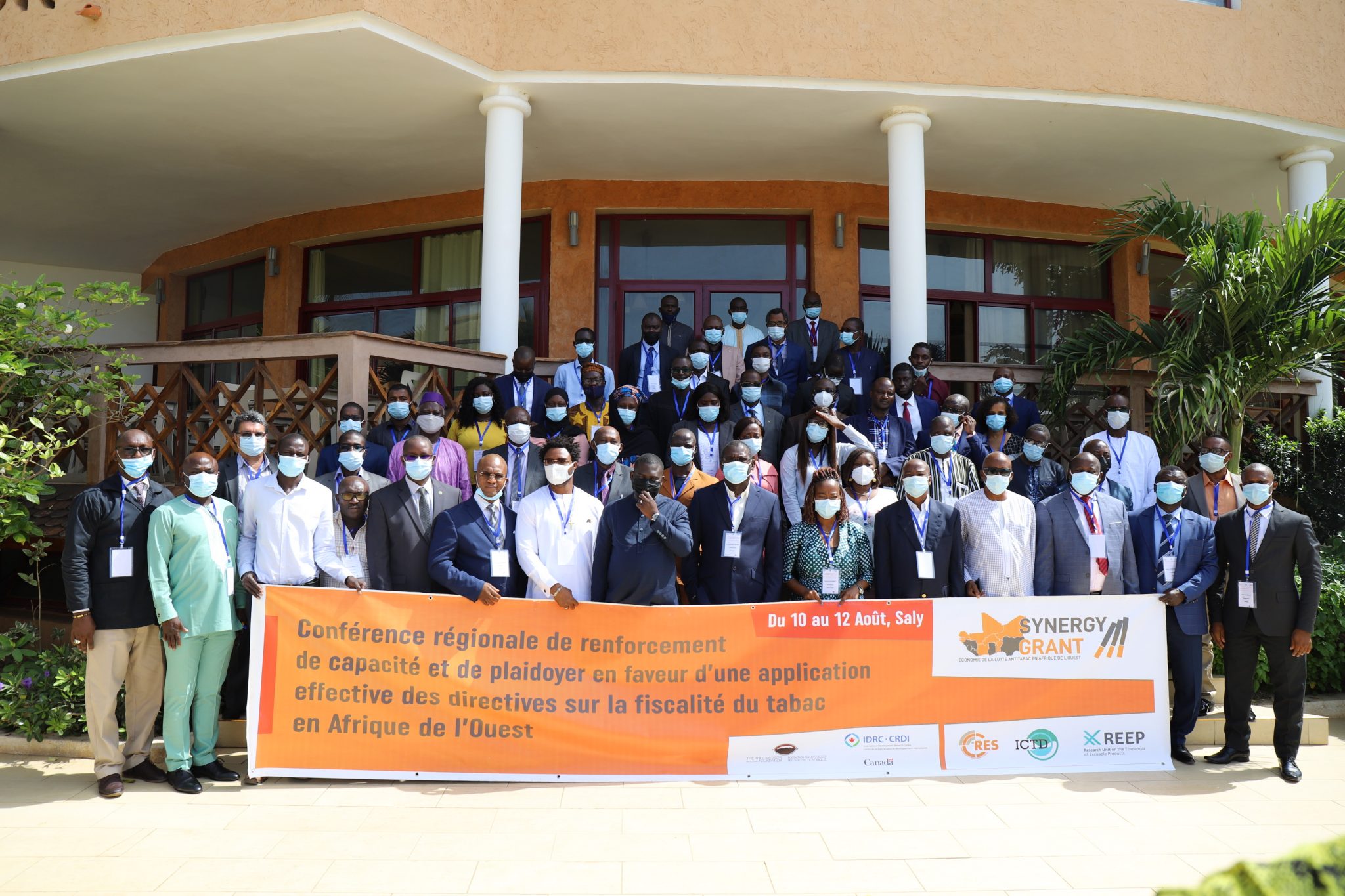 attendees together outside the conference centre with a banner