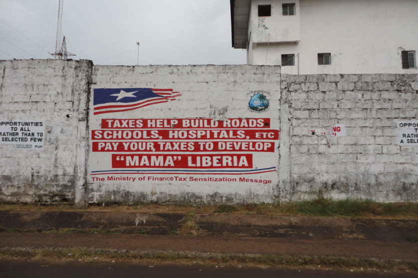 Picture of wall with tag on paying taxes for development in Liberia