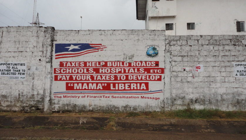 Picture of wall with tag on paying taxes for development in Liberia