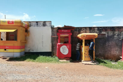 Two men standing in front of a mobile money kiosk in Entebbe, Uganda