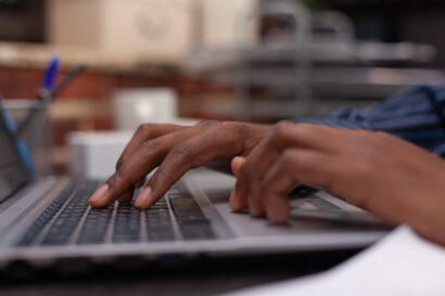 Close-up image of a person's hands typing on a computer.