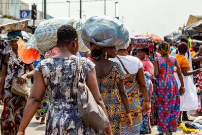 Women walking in a street in Adjamé Market, Abijan, Ivory Coast. Some are carrying their wares on their heads.