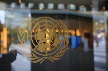 Logo of the United Nations embossed on a glass wall in the UN Headquarters in New York City