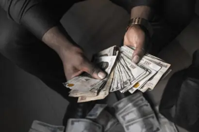 Close up shot of a person's hands holding loads of Nigerian cash