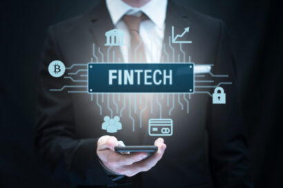 Fintech financial technology concept image showing Fintech icon hovering over a smartphone, held by a business person.