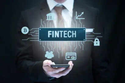 Fintech financial technology concept image showing Fintech icon hovering over a smartphone, held by a business person.