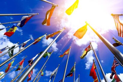 International flags on flag-poles against a back-drop of blue sky and some cloulds.