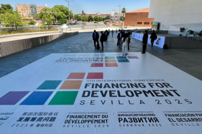 A large white banner laid out on the floor, with text that reads "Financing for Development Sevilla 2025"
