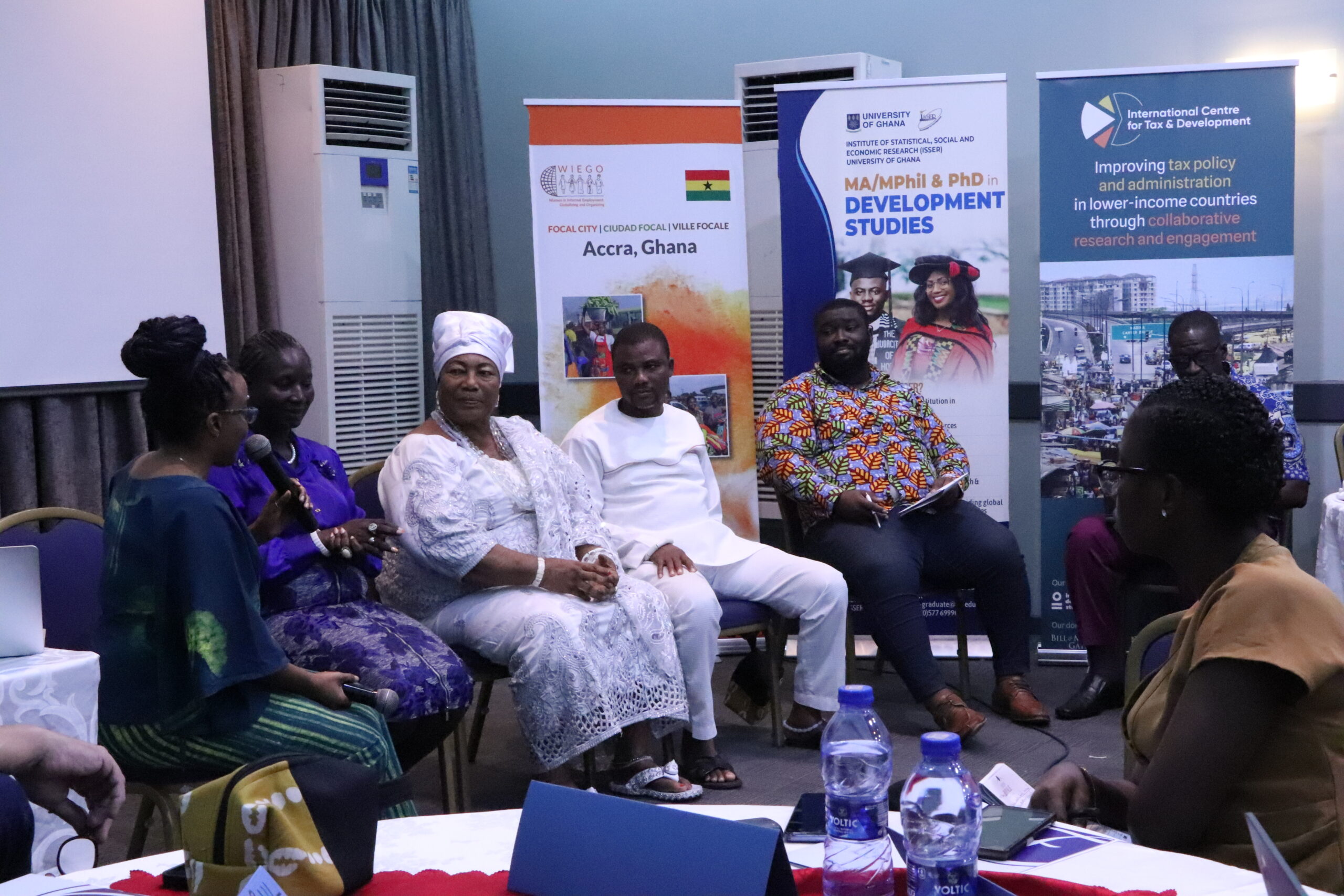 A panel of five speakers with three women, and two men, sitting and having a discussion.