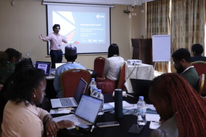 Wide angle of a closed conference room showing the participants to the ICTD tax course from the back as they listen to a session delivered by the course co-lead.