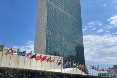 Vertical shot of the UN headquarters in New York, featuring a row of flags from different countries