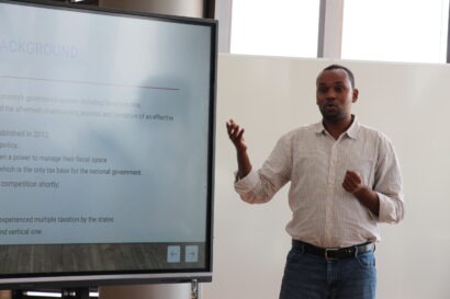 Najibullah Nor Isak, ICTD tax course alum, standing in front of a projected screen as he delivers a presentation to an audience that is not seen in the picture.
