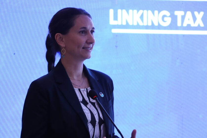 Giulia Mascagni stands by a large screen, giving a presentation.