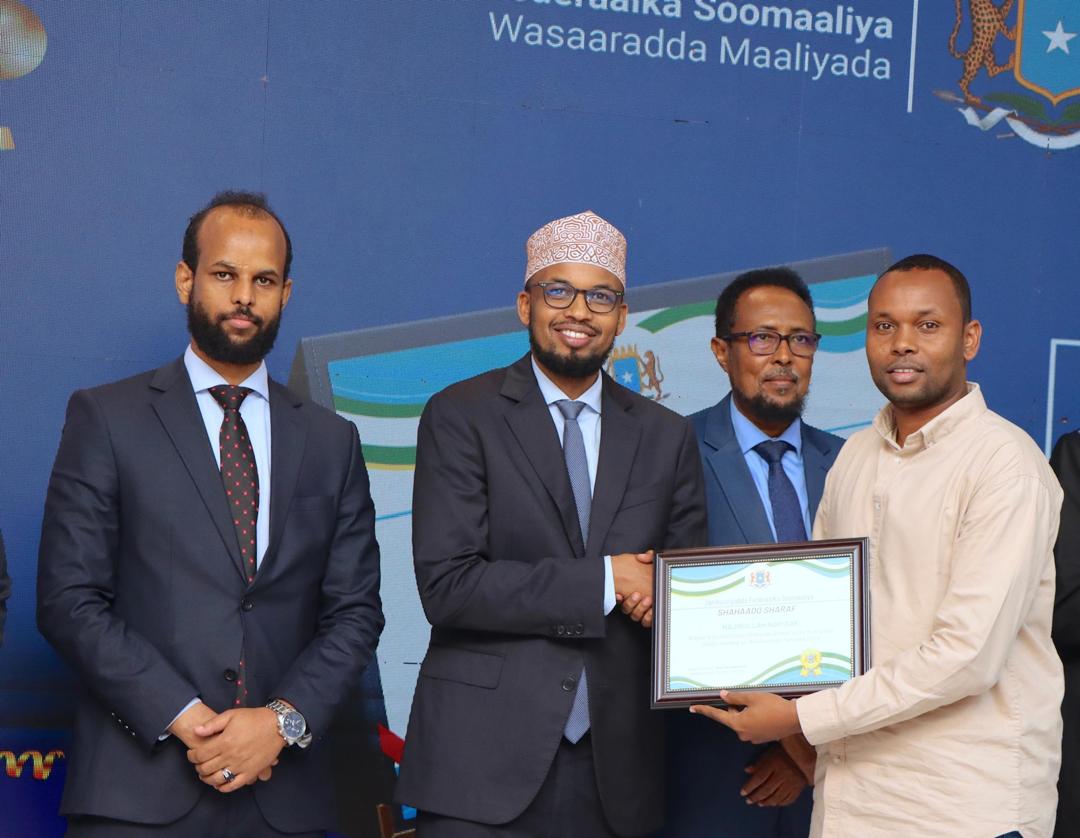 Najibullah No Isak (first from the right) standing with the Deputy Minister and two Directors General from the Ministry of Finance in Somalia as he was representing the Tax Policy Team and accepting on their behalf an appreciation award.