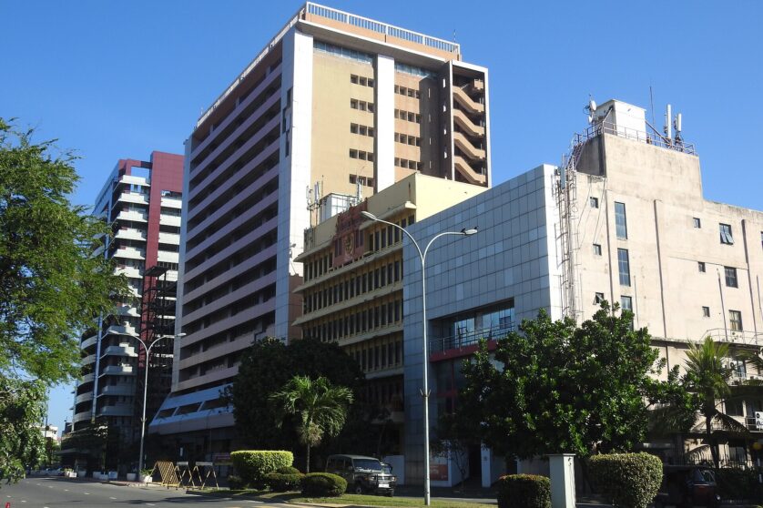 Medium-rise buildings along a road, with a prominent yellow building sticking out