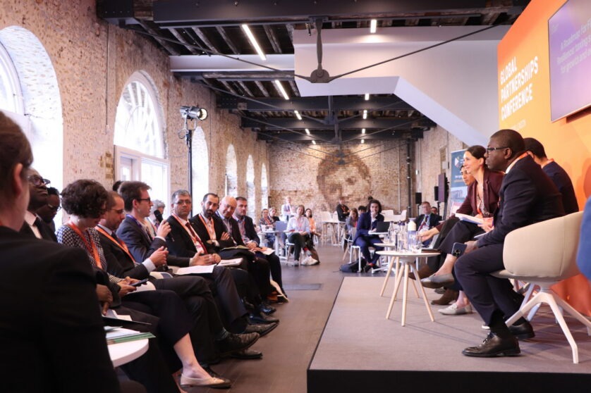 Side view of the stage with all speakers facing the audience at the FCDO Global Partnerships Conference