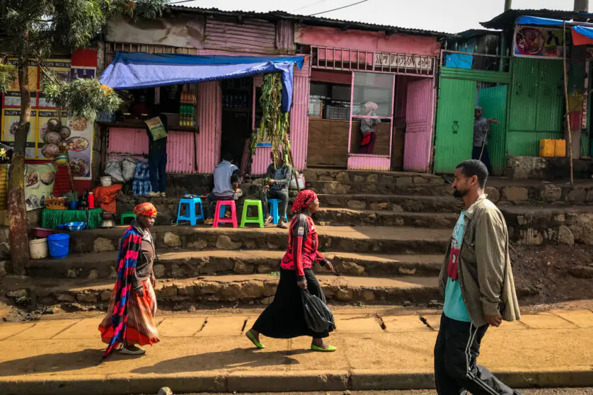 Small business shack in Addis Ababa, Ethiopia with people walking in front.