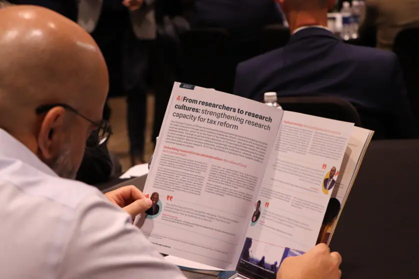 Man with his back to the camera reading the ICTD report on Taxing Smarter