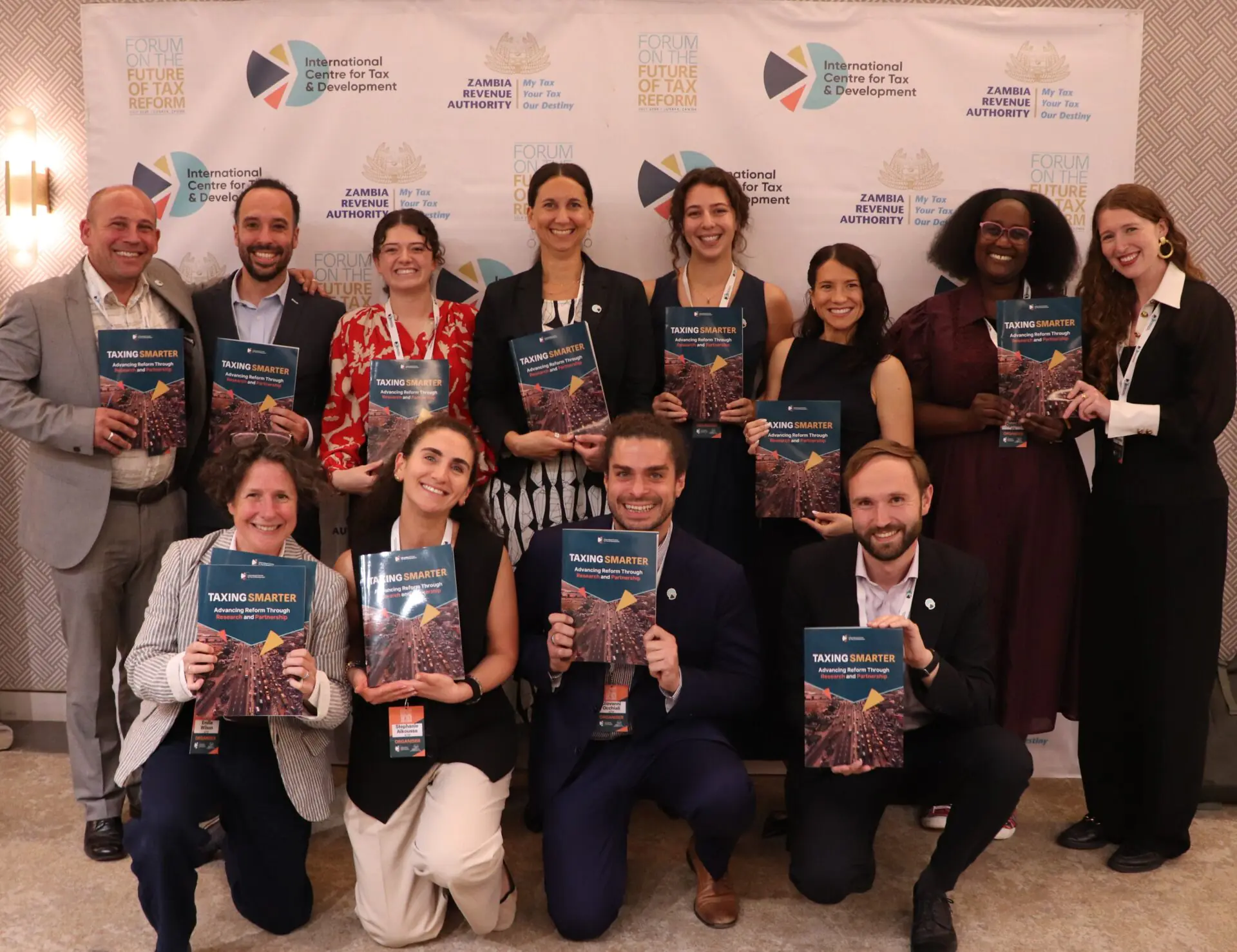 Members of the ICTD team holding copies of the Taxing Smarter report