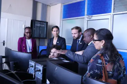 A group of individuals looking intently on a set of computers.